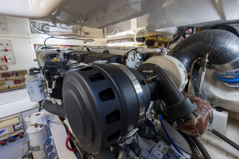 Slide: The Image of Engine room of a 2005 Cabo 40 Flybridge boat, showcasing detailed machinery and components. - 72