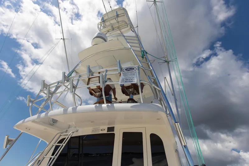 Slide: The Image of 2005 Cabo 40 Flybridge yacht against a cloudy sky, showcasing its sleek design and structure. - 74