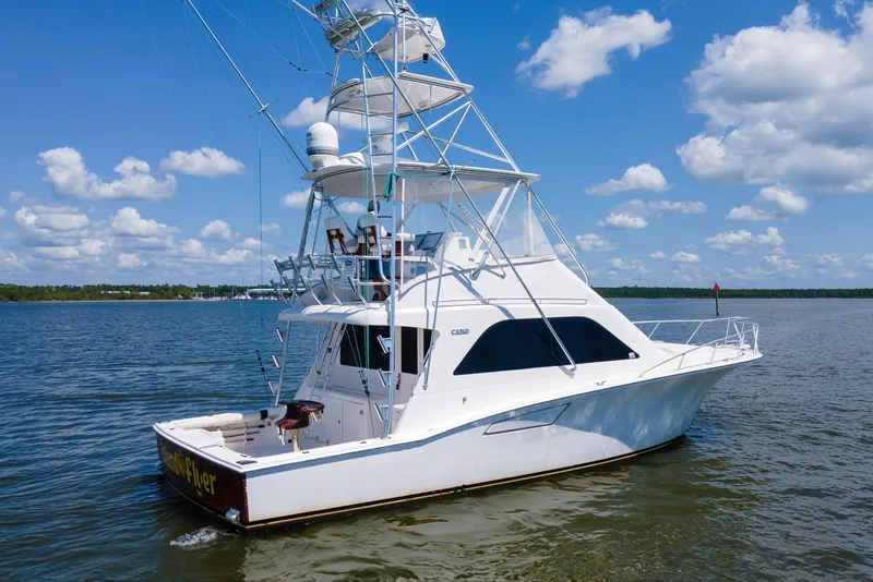 Slide: The Image of 2005 Cabo 40 Flybridge yacht on calm waters under a blue sky. - 78