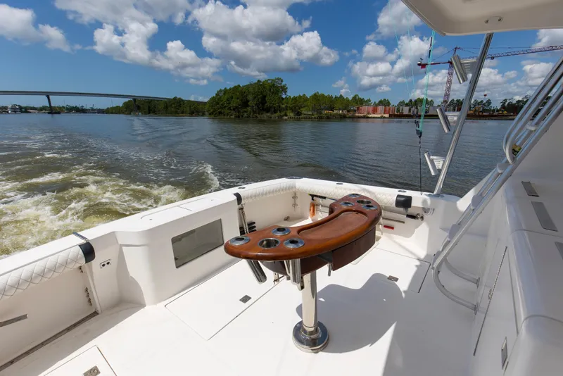 Slide: The Image of 2005 Cabo 40 Flybridge yacht deck with fishing rod holders on a sunny day. - 9