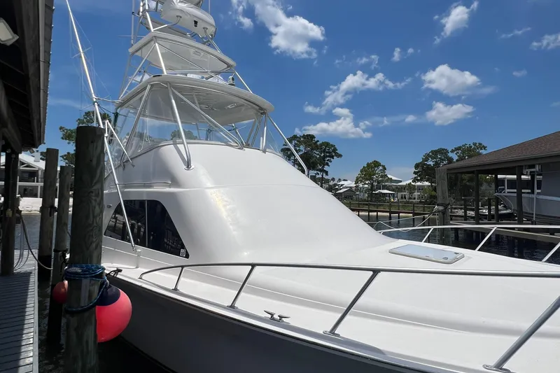 Slide: The Image of 2005 Cabo 40 Flybridge yacht docked under a clear blue sky. - 98