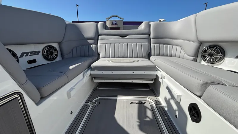 Slide: The Image of Interior of 2025 MB B52 25 Alpha boat with gray seating and speakers. - 19