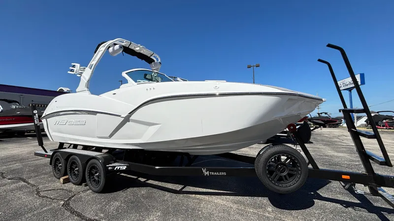 Slide: The Image of 2025 MB B52 25 Alpha boat on trailer, displayed outdoors under clear blue sky. - 2