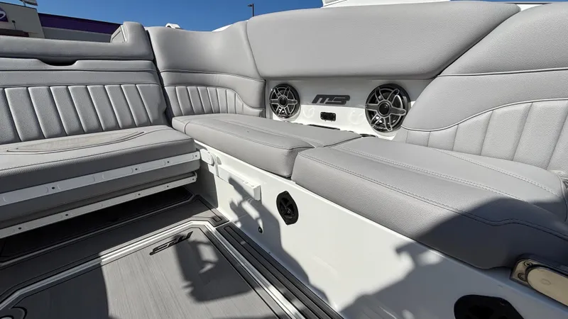 Slide: The Image of Interior of 2025 MB B52 25 Alpha boat with gray seating and speakers. - 20