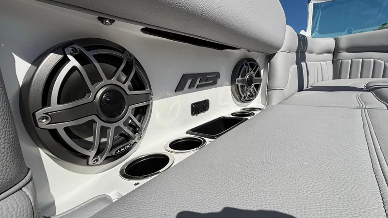 Slide: The Image of Luxury boat interior with JL Audio speakers, cup holders, and plush seating in MB B52 25 Alpha 2025. - 22