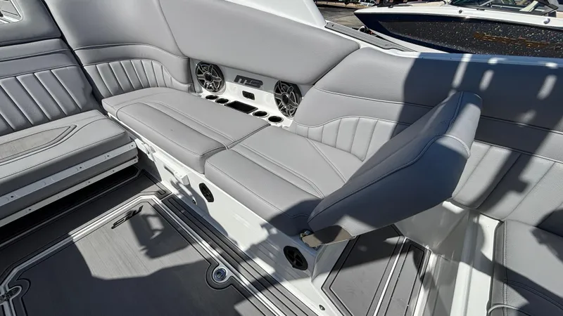 Slide: The Image of 2025 MB B52 25 Alpha boat interior with gray seating and built-in speakers. - 27