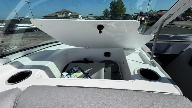 Slide: The Image of Open storage compartment in 2025 MB B52 25 Alpha boat, featuring cup holders and seating. - 40