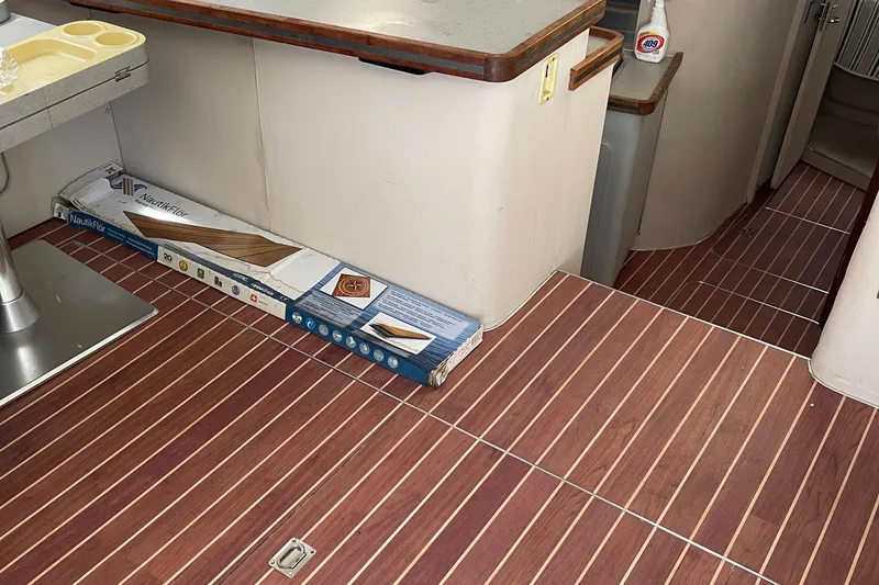 Slide: The Image of 1988 Trojan 12 Meter Convertible interior with wood flooring and Nautikflor packaging. - 36