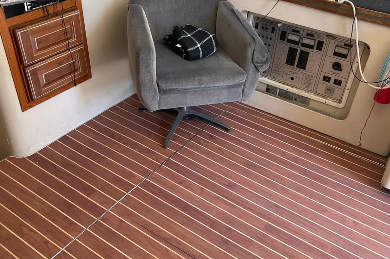 Slide: The Image of 1988 Trojan 12 Meter Convertible interior with control panel, swivel chair, and wood-patterned flooring. - 37