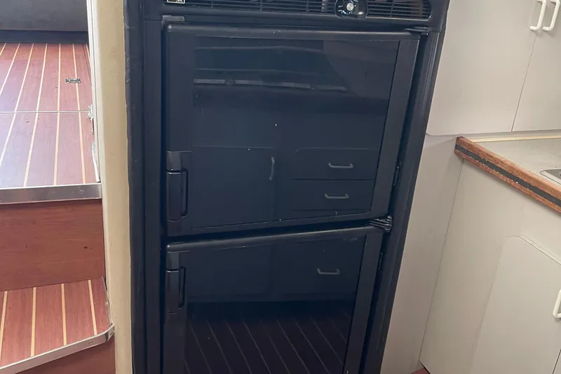 Slide: The Image of Black refrigerator inside 1988 Trojan 12 Meter Convertible yacht kitchen. - 40