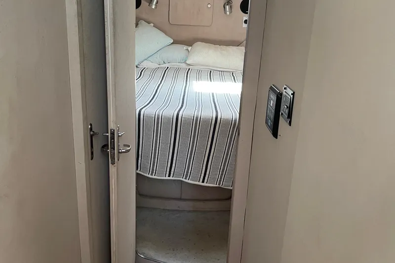 Slide: The Image of Cozy cabin interior of 1988 Trojan 12 Meter Convertible yacht with striped bedding. - 43