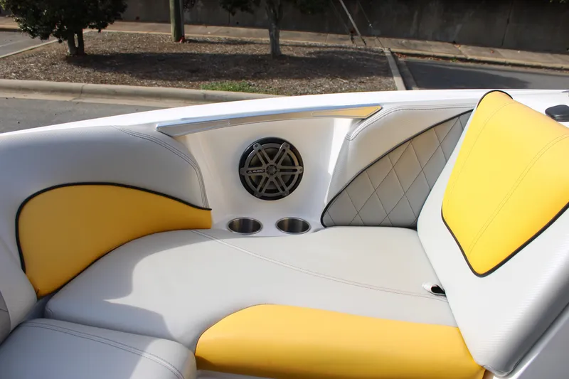 Slide: The Image of 2013 MasterCraft X-2 boat interior with yellow and gray seating, speaker, and cup holders. - 34