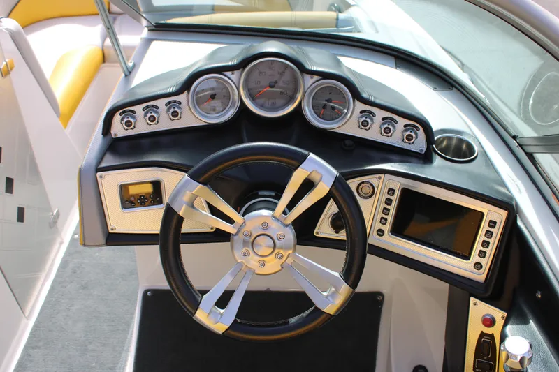 Slide: The Image of 2013 MasterCraft X-2 boat dashboard with steering wheel and control gauges. - 35
