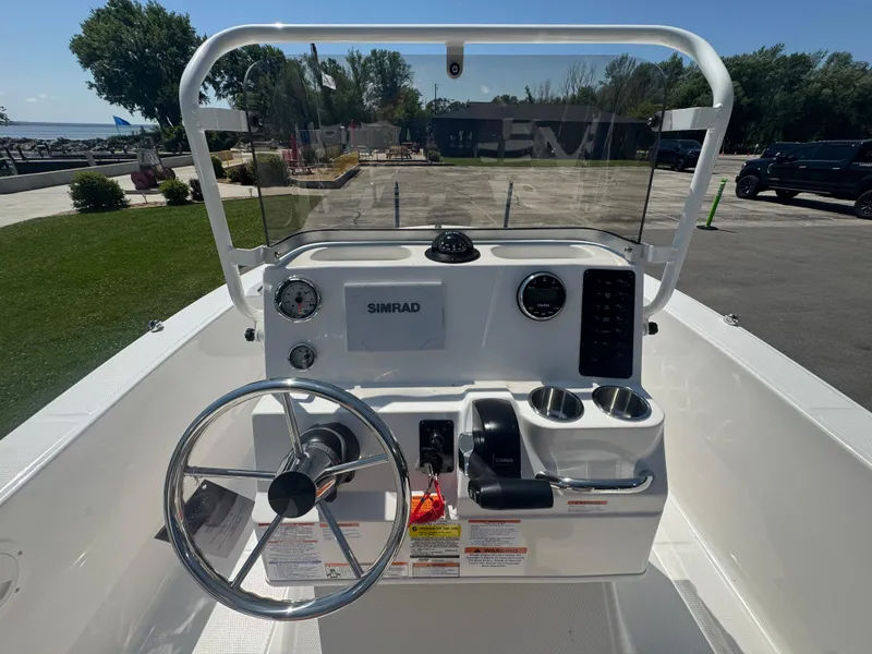 Slide: The Image of 2025 Robalo R160 Center Console boat dashboard with steering wheel and Simrad display. - 11