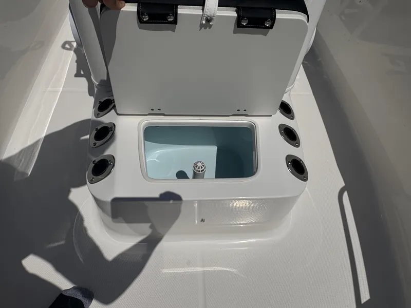 Slide: The Image of 2025 Robalo R160 Center Console livewell with open lid and rod holders. - 14