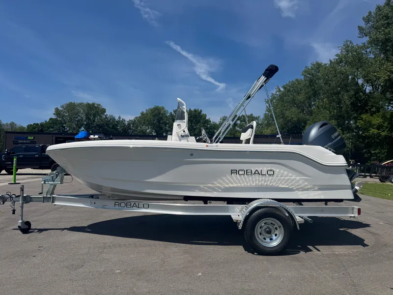 Slide: The Image of 2025 Robalo R160 Center Console boat on trailer under clear blue sky. - 4