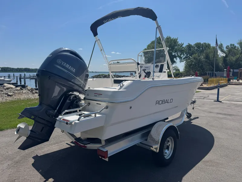 Slide: The Image of 2025 Robalo R160 Center Console boat with Yamaha engine on trailer by waterfront. - 6