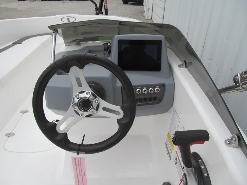 Slide: The Image of 2023 Tahoe T16 boat dashboard with steering wheel and control panel. - 6