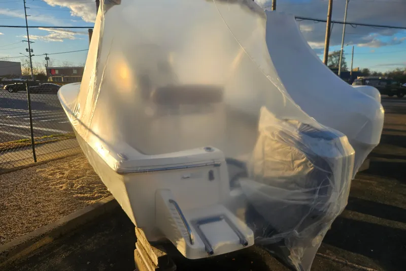 The Image of 2013 Scout 195 Sportfish boat covered in protective wrap, parked outdoors. - 0