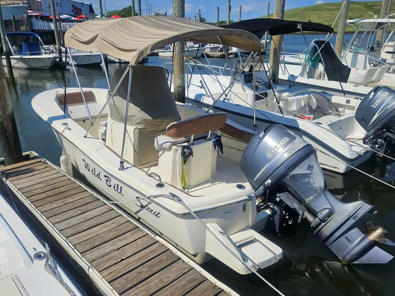 Slide: The Image of 2013 Scout 195 Sportfish boat docked with Yamaha outboard motor and canopy. - 2