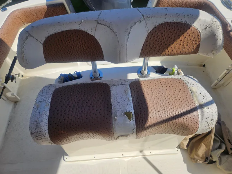 Slide: The Image of Worn seating on 2013 Scout 195 Sportfish boat, showing cracked upholstery and textured design. - 6