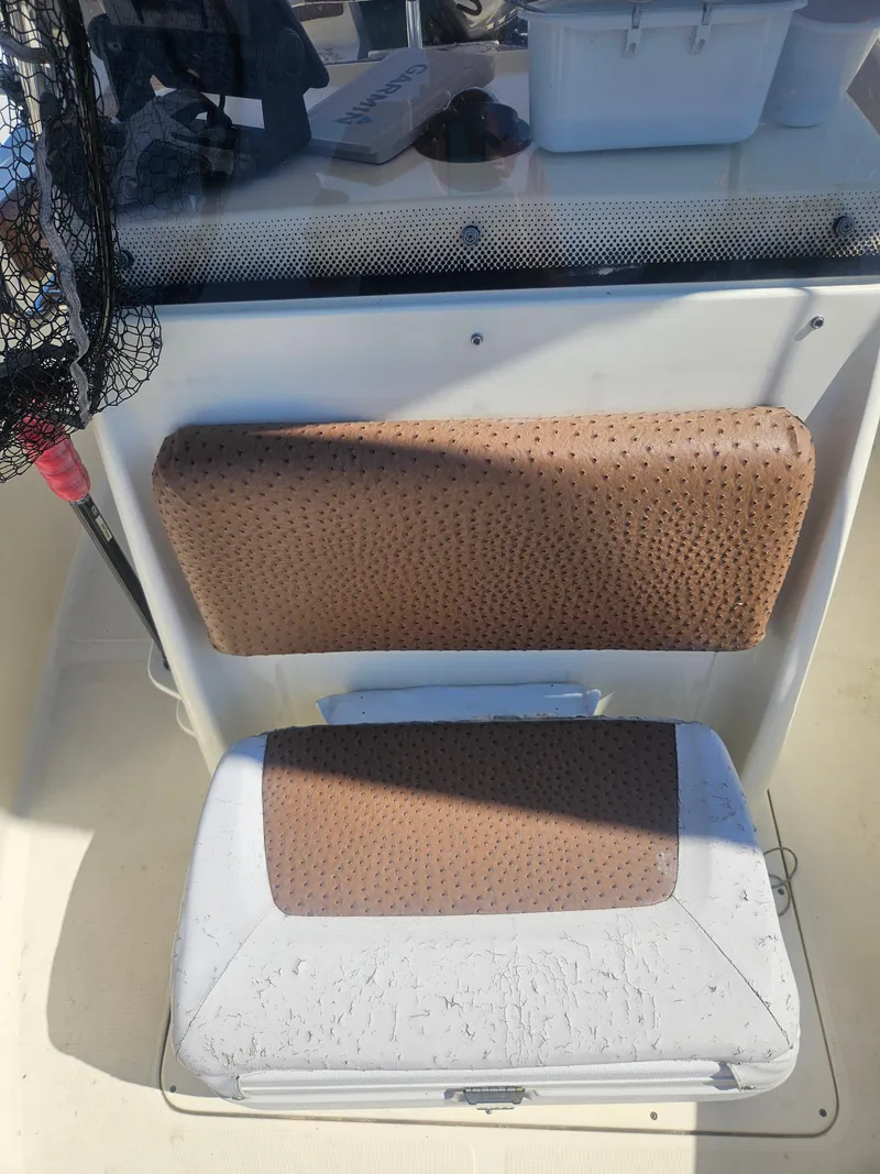 Slide: The Image of 2013 Scout 195 Sportfish boat seat with brown upholstery and fishing gear. - 7