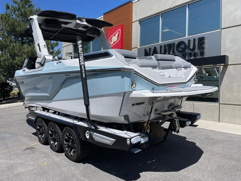 Slide: The Image of 2025 Nautique Super Air Nautique G25 Paragon boat on trailer outside dealership. - 3