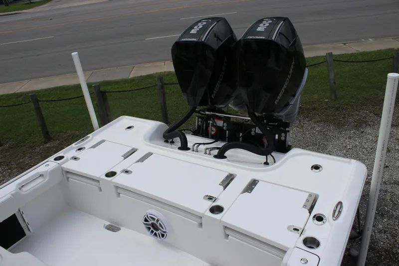 Slide: The Image of 2026 Tidewater 2700 Carolina Bay boat with dual Mercury outboard engines, docked on gravel. - 20