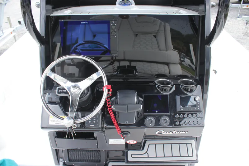 Slide: The Image of 2026 Tidewater 2700 Carolina Bay helm with steering wheel, controls, and navigation display. - 23