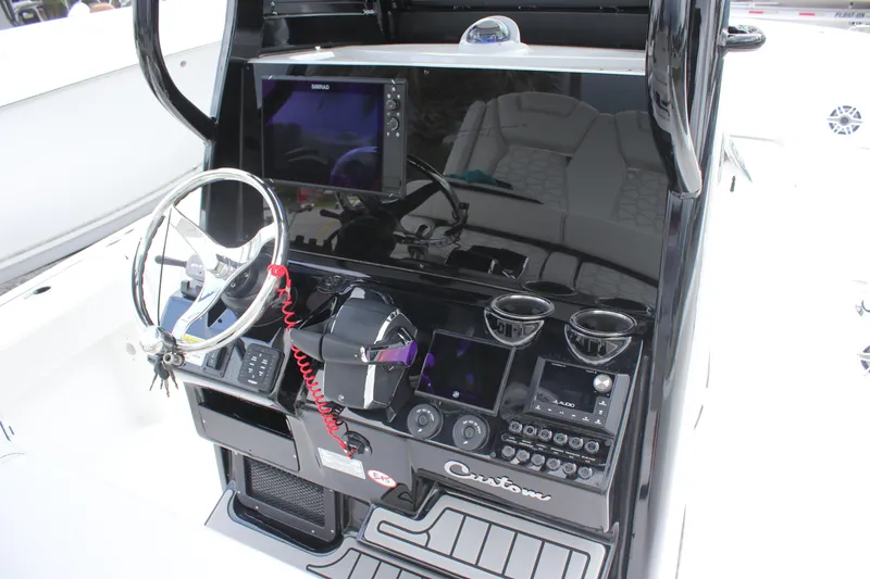 Slide: The Image of 2026 Tidewater 2700 Carolina Bay boat console with steering wheel and electronic controls. - 24