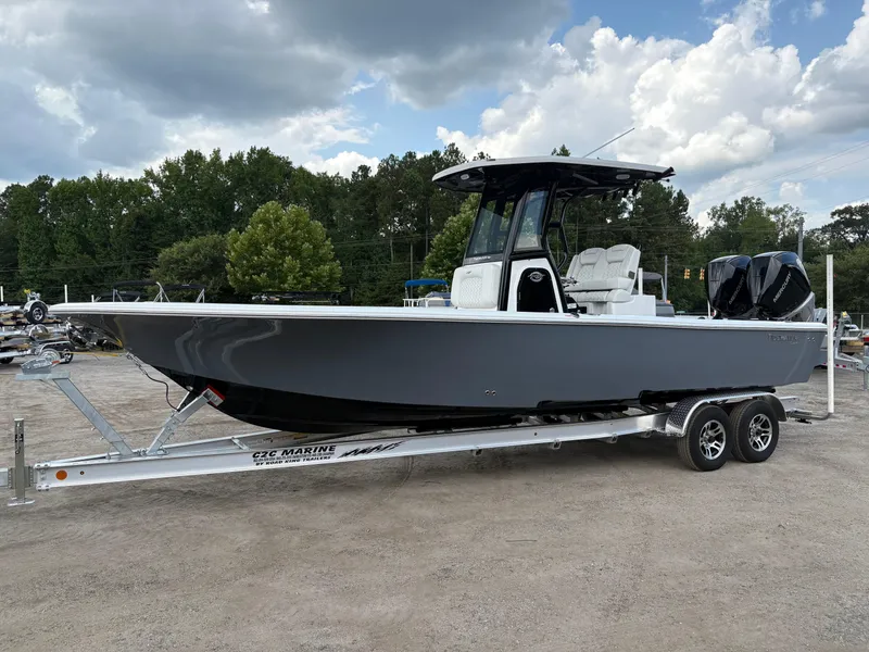 Slide: The Image of 2026 Tidewater 2700 Carolina Bay boat on trailer, parked outdoors under cloudy sky. - 3