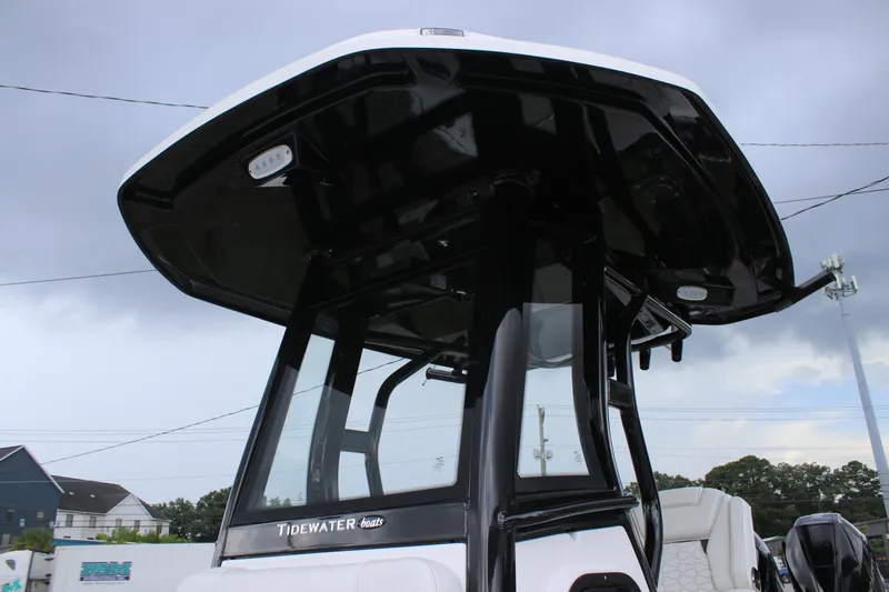 Slide: The Image of 2026 Tidewater 2700 Carolina Bay boat with sleek black T-top under cloudy sky. - 36