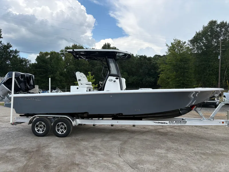 Slide: The Image of 2026 Tidewater 2700 Carolina Bay boat on trailer, parked outdoors under cloudy sky. - 6