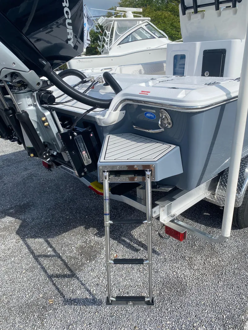 Slide: The Image of 2026 Tidewater 2700 Carolina Bay boat with ladder and Mercury engine, parked on gravel. - 7