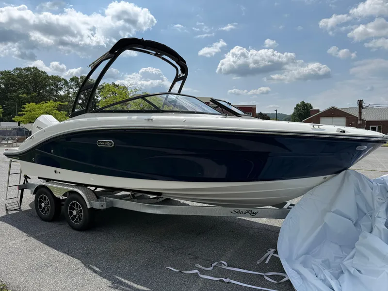 Slide: The Image of 2026 Sea Ray SPX 210 Outboard boat on trailer under a partly cloudy sky. - 2