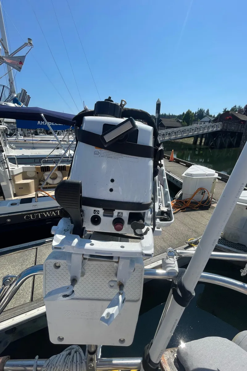 Slide: The Image of Outboard motor mounted on Jeanneau Sun Odyssey 36 sailboat, docked at marina, sunny day. - 16