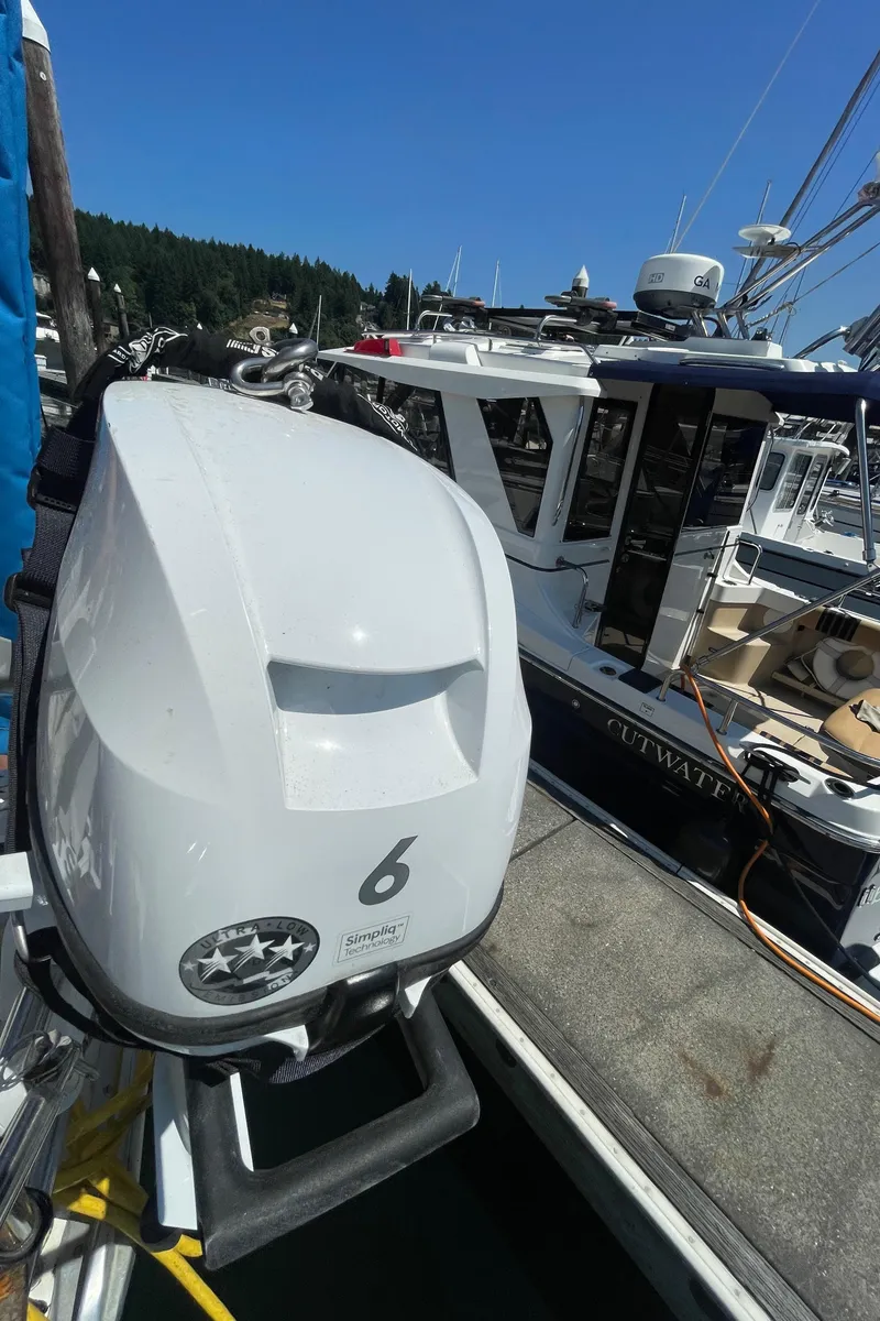 Slide: The Image of Outboard motor on Jeanneau Sun Odyssey 36, docked near other boats, clear blue sky. - 17