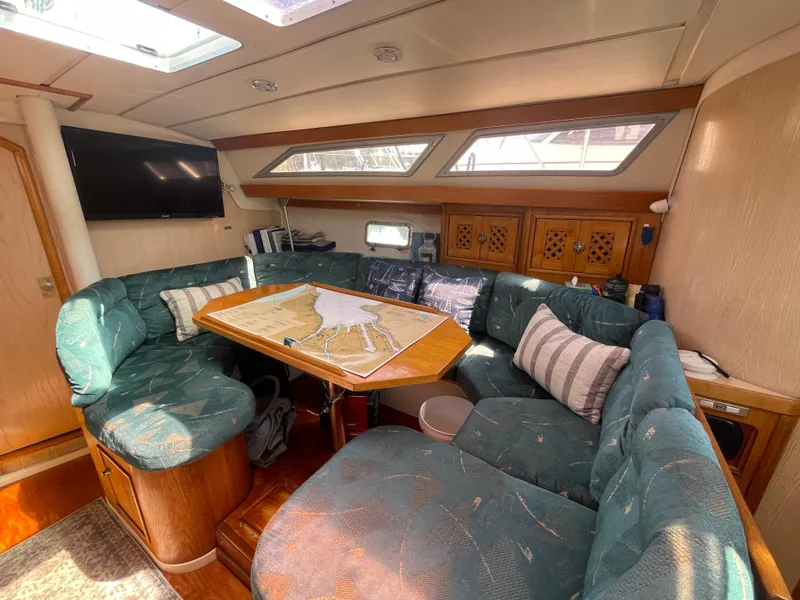 Slide: The Image of Cozy interior of 1990 Jeanneau Sun Odyssey 36 sailboat with map on table. - 26