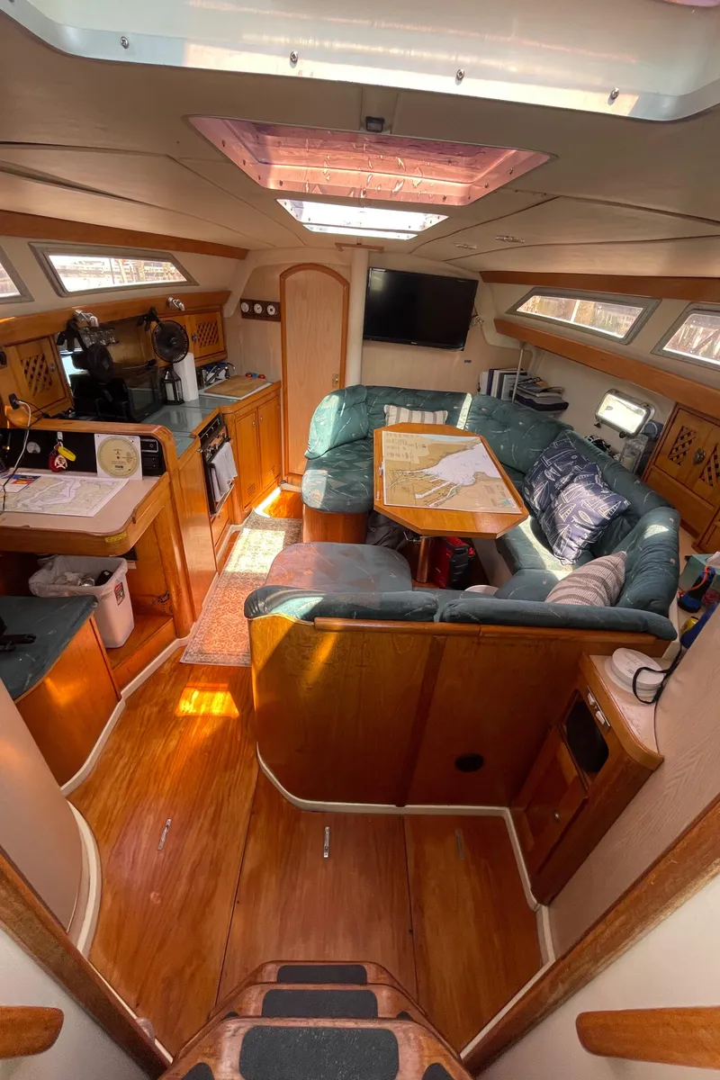 Slide: The Image of Interior of 1990 Jeanneau Sun Odyssey 36 sailboat with cozy seating and wooden finishes. - 27