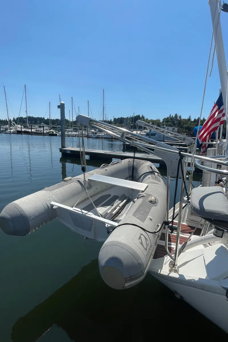Slide: The Image of Jeanneau Sun Odyssey 36 sailboat with dinghy docked at marina, 1990 model. - 3