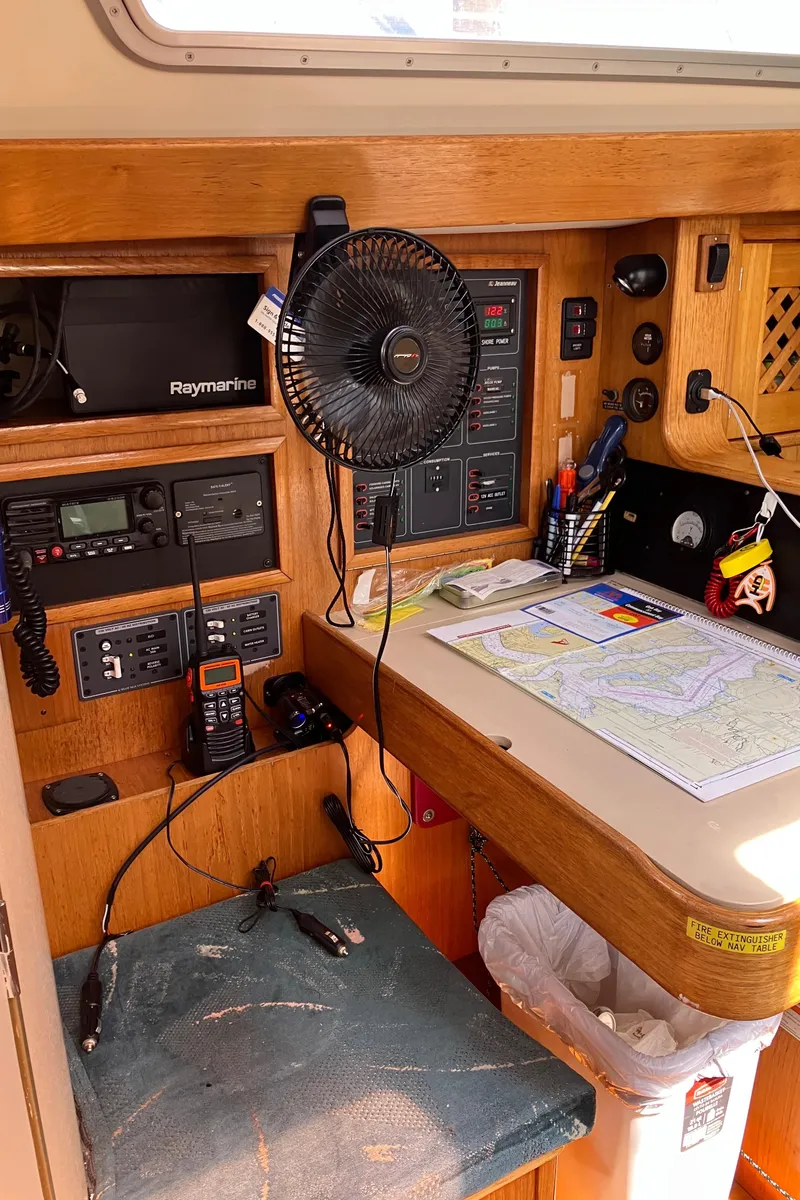 Slide: The Image of Navigation station on a 1990 Jeanneau Sun Odyssey 36 sailboat with maps and communication equipment. - 30