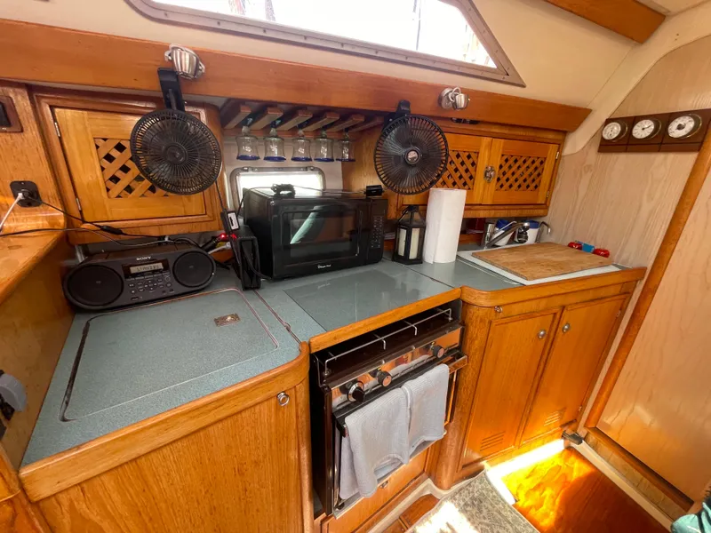 Slide: The Image of Interior of 1990 Jeanneau Sun Odyssey 36 yacht kitchen with wooden cabinets and appliances. - 32