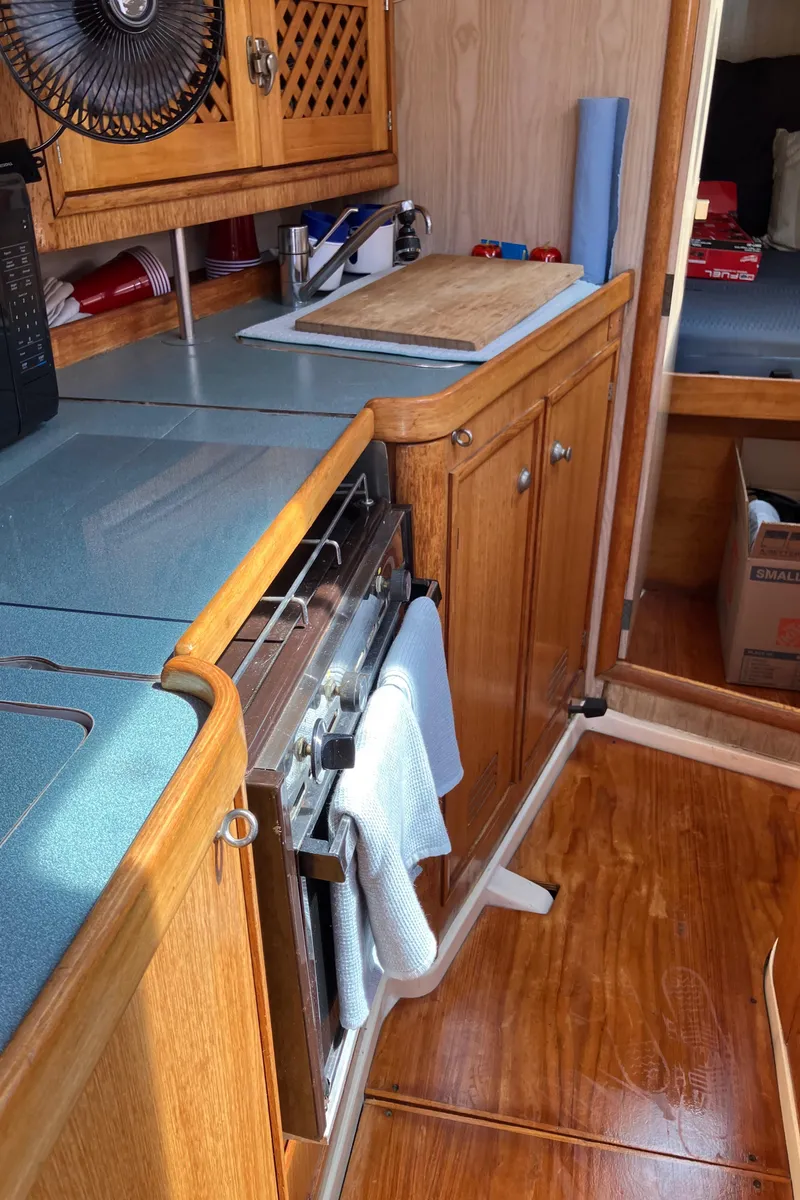 Slide: The Image of Interior of 1990 Jeanneau Sun Odyssey 36 sailboat kitchen with wooden cabinetry. - 33