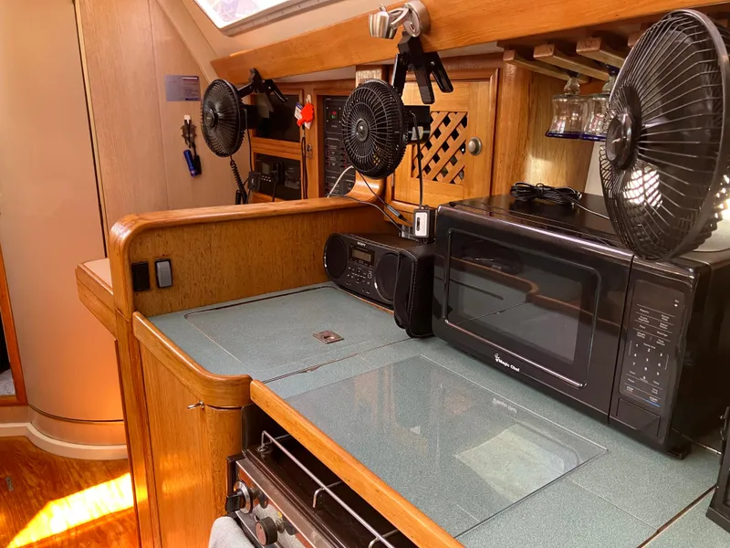 Slide: The Image of Interior of 1990 Jeanneau Sun Odyssey 36 yacht kitchen with microwave and fans. - 34