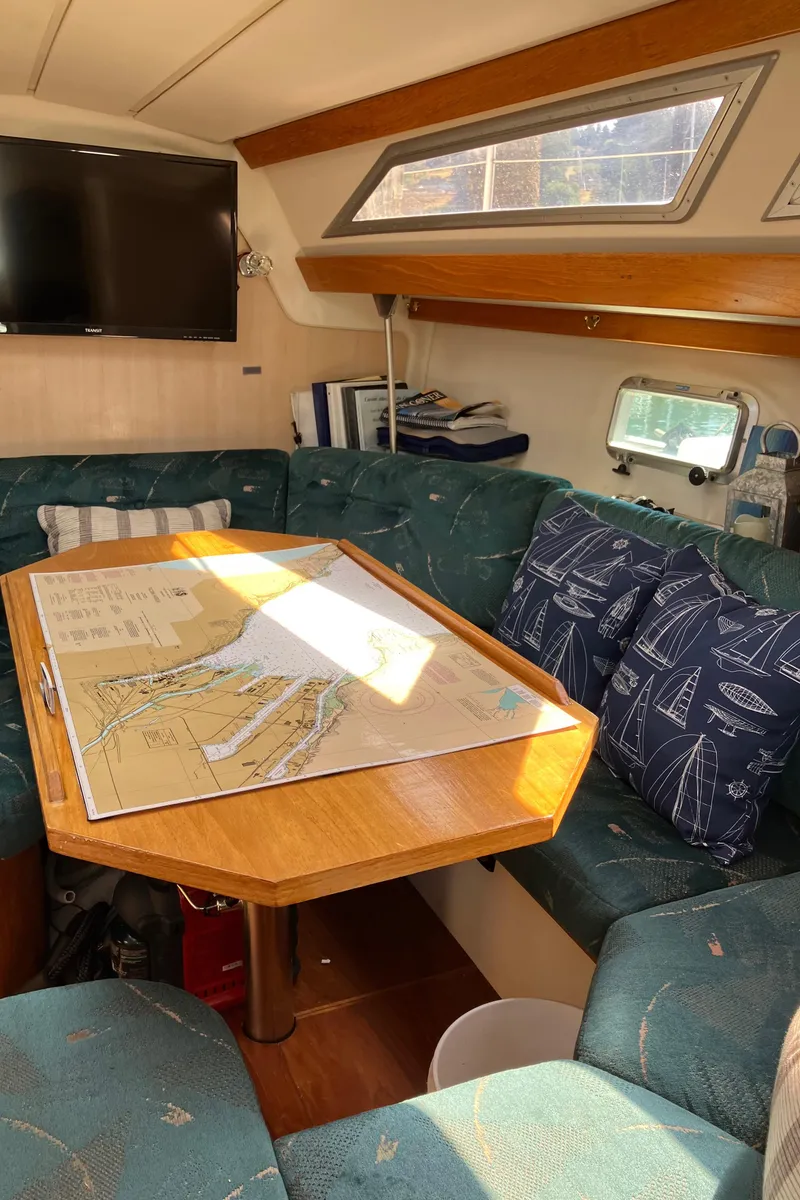 Slide: The Image of Cozy interior of 1990 Jeanneau Sun Odyssey 36 sailboat with map on table. - 37