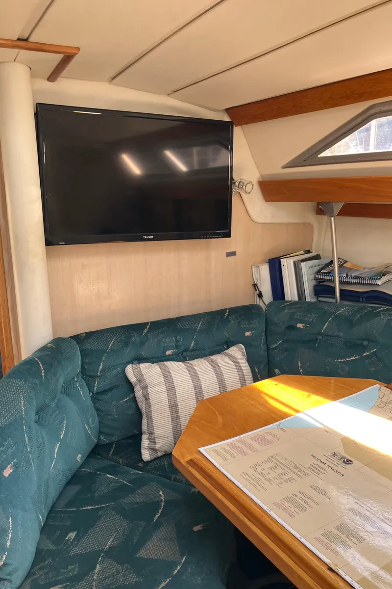 Slide: The Image of Interior of 1990 Jeanneau Sun Odyssey 36 yacht with TV, seating, and navigation table. - 38