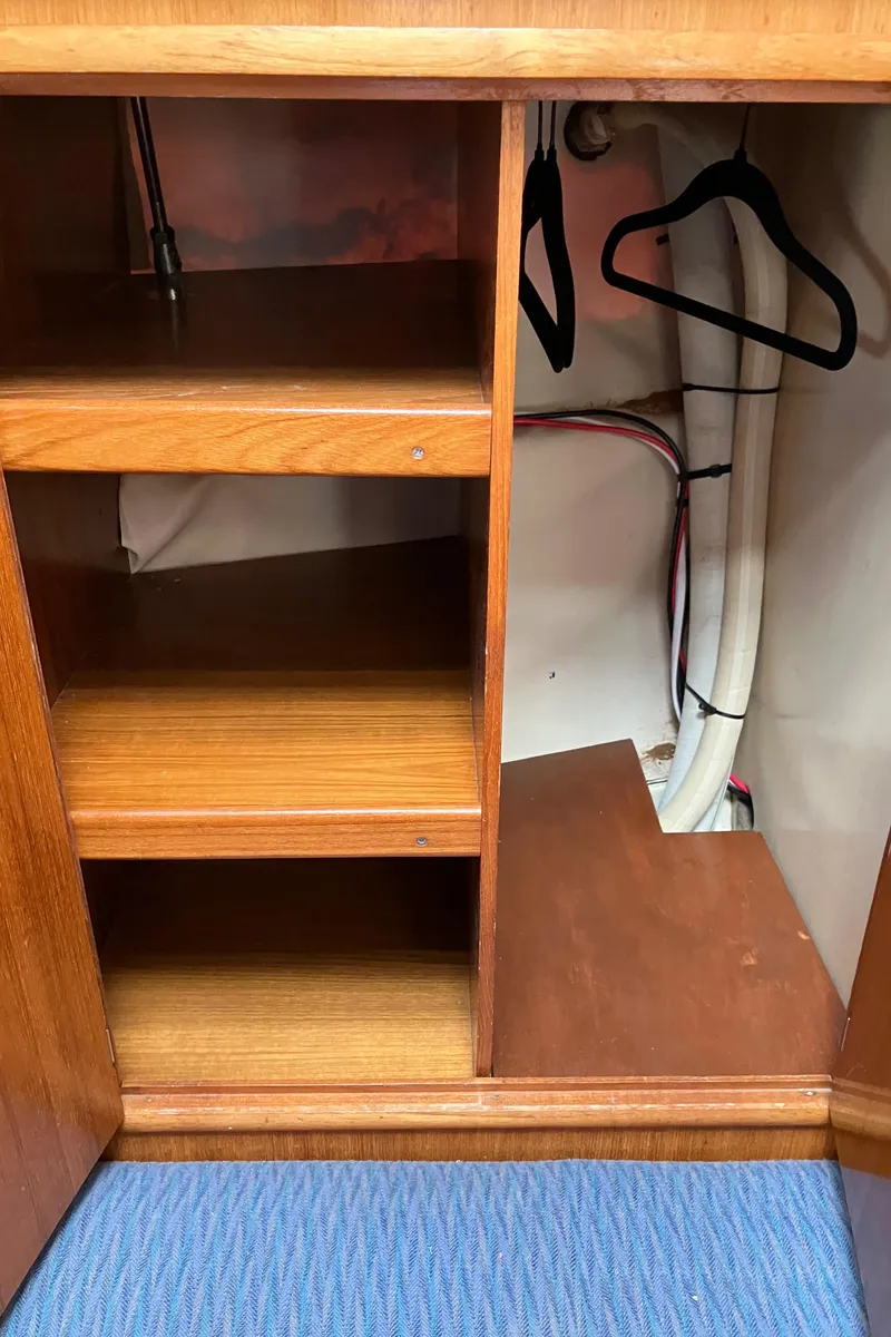 Slide: The Image of Interior storage of 1990 Jeanneau Sun Odyssey 36 sailboat with wooden shelves and hangers. - 39