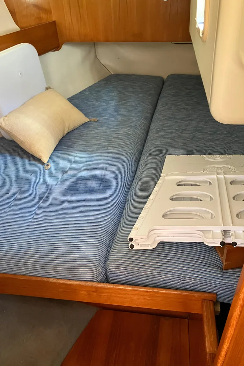 Slide: The Image of Cozy cabin interior of 1990 Jeanneau Sun Odyssey 36 sailboat with blue-striped bedding. - 44