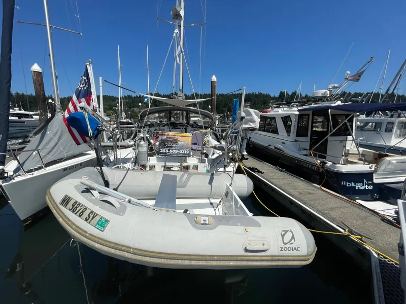 Slide: The Image of 1990 Jeanneau Sun Odyssey 36 sailboat docked with inflatable Zodiac dinghy. - 46