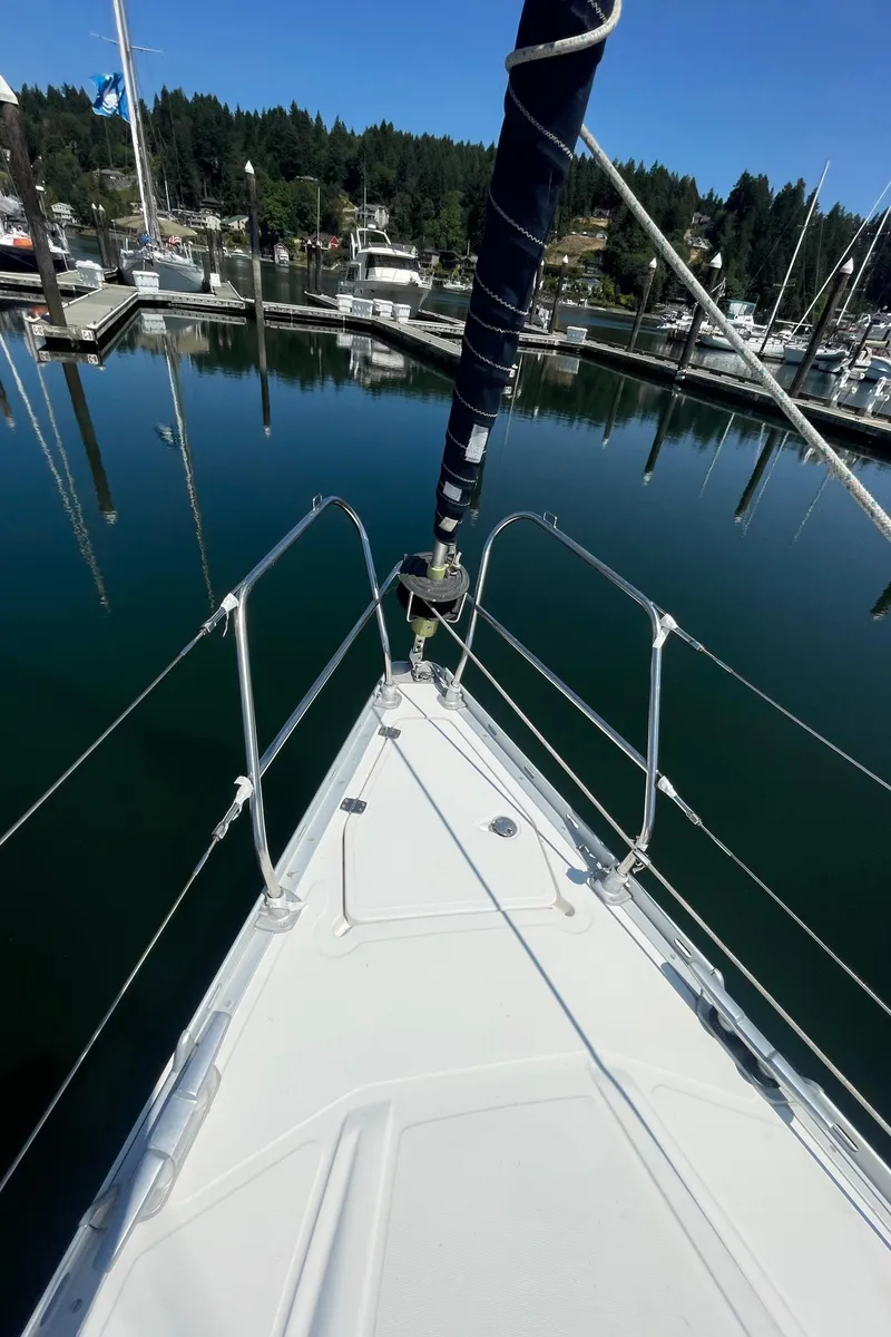 Slide: The Image of Jeanneau Sun Odyssey 36 sailboat docked in a serene marina, 1990 model. - 5